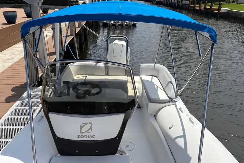 Slide: The Image of 2021 Zodiac N-ZO 680 boat with blue canopy docked by the water. - 17