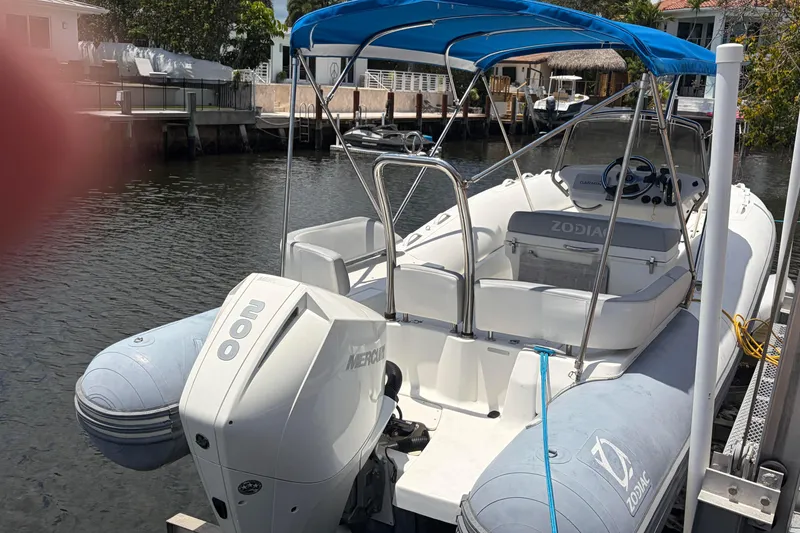 Slide: The Image of 2021 Zodiac N-ZO 680 boat docked with blue canopy and Mercury 200 engine. - 24