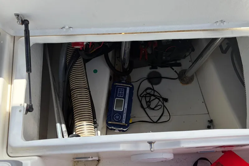 Slide: The Image of Open storage compartment of 2021 Zodiac N-ZO 680 boat with equipment and wiring. - 26