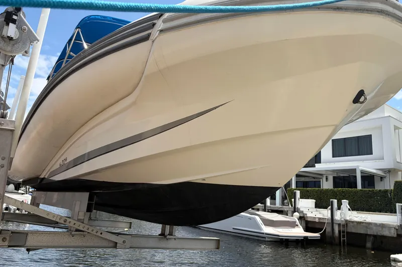 Slide: The Image of 2021 Zodiac N-ZO 680 boat on lift, dockside view with modern architecture. - 4