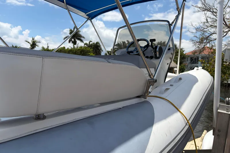 Slide: The Image of 2021 Zodiac N-ZO 680 boat with blue canopy, docked under a sunny sky. - 6