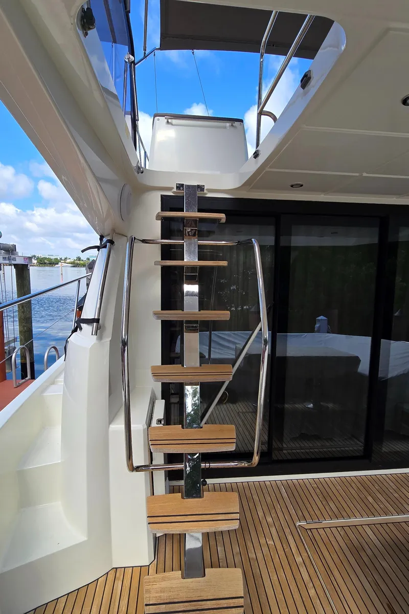 Slide: The Image of Staircase on 2018 Prestige 460 yacht, leading to upper deck with glass doors and wooden flooring. - 10