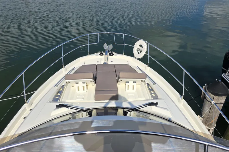 Slide: The Image of Bow view of 2018 Prestige 460 yacht with sun pads and railing on calm water. - 16