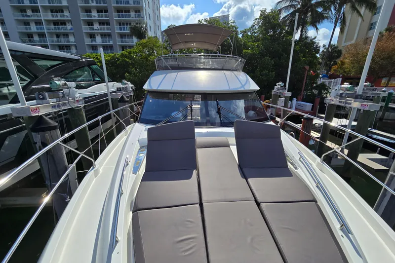Slide: The Image of 2018 Prestige 460 yacht docked, featuring spacious sunbathing area and sleek design. - 17