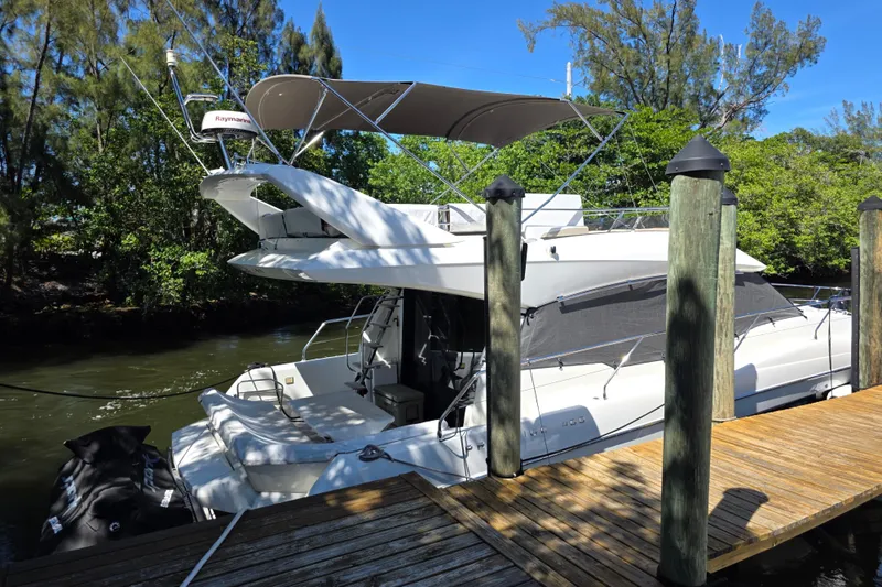 Slide: The Image of 2018 Prestige 460 yacht docked by a wooden pier, surrounded by lush greenery. - 2