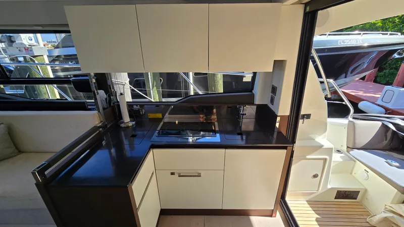 Slide: The Image of Modern kitchen area on a 2018 Prestige 460 yacht, featuring sleek cabinetry and appliances. - 21