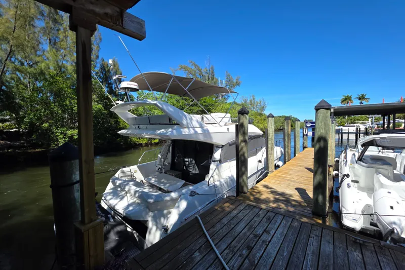 Slide: The Image of 2018 Prestige 460 yacht docked at a sunny marina with lush greenery. - 3