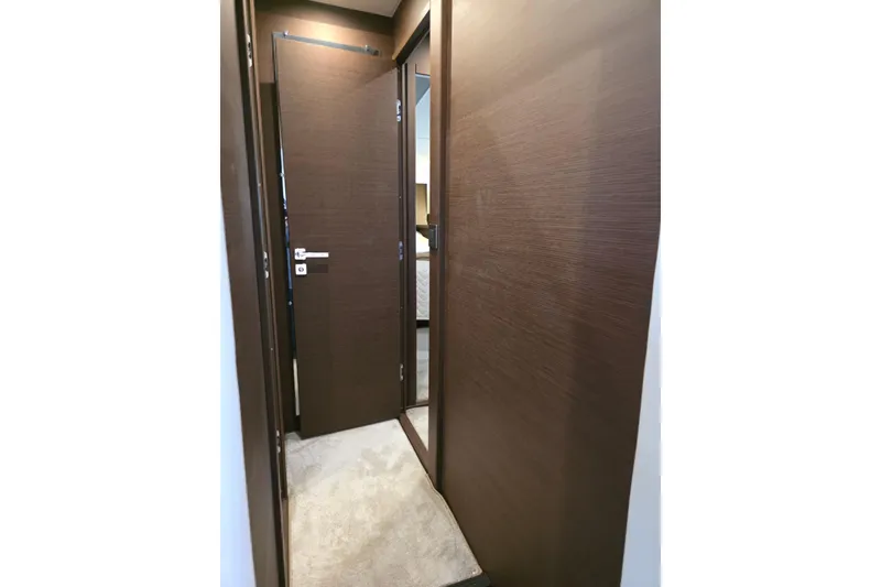 Slide: The Image of Interior hallway of a 2018 Prestige 460 yacht with wooden doors and carpet flooring. - 33