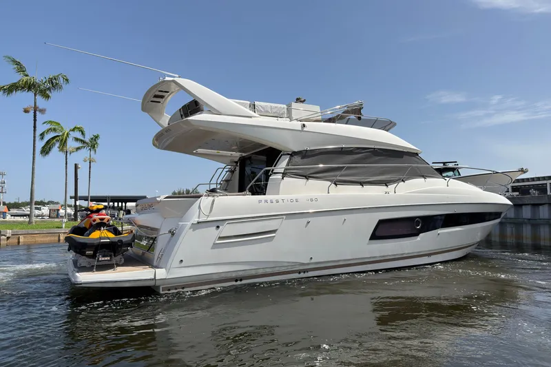 The Image of 2018 Prestige 460 yacht on water, palm trees in background. - 0