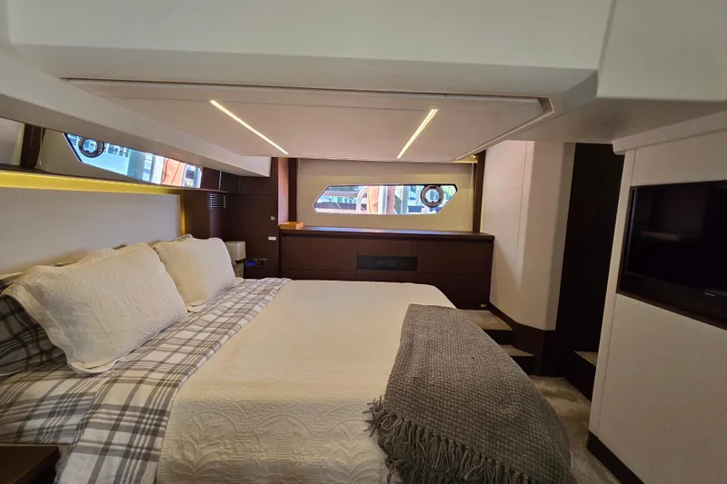 Slide: The Image of Luxurious bedroom interior of a 2018 Prestige 460 yacht, featuring elegant bedding and modern design. - 38