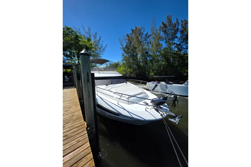 Slide: The Image of 2018 Prestige 460 yacht docked by a wooden pier, surrounded by lush greenery. - 4