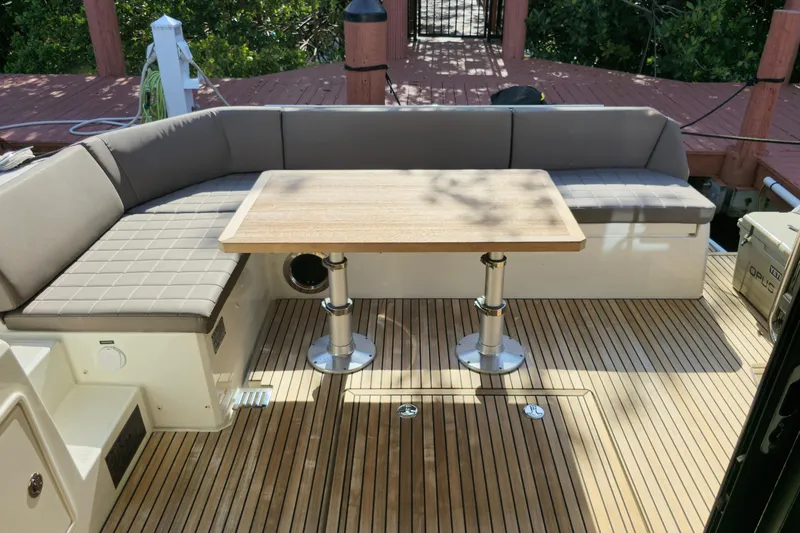 Slide: The Image of Luxurious seating area on 2018 Prestige 460 yacht with wooden table and cushioned benches. - 6