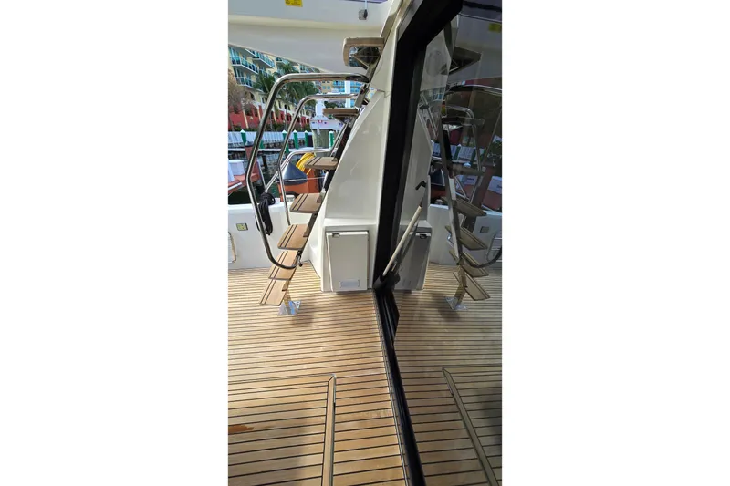 Slide: The Image of Prestige 460 yacht deck with wooden flooring and metal stairs, 2018 model. - 8