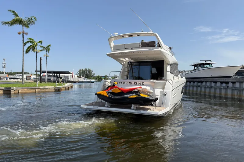 Slide: The Image of 2018 Prestige 460 yacht with jet ski on deck, cruising in a sunny marina. - 45