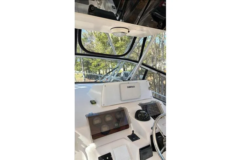 Slide: The Image of 1999 Grady-White Marlin 300 boat cockpit with steering wheel and navigation instruments. - 11