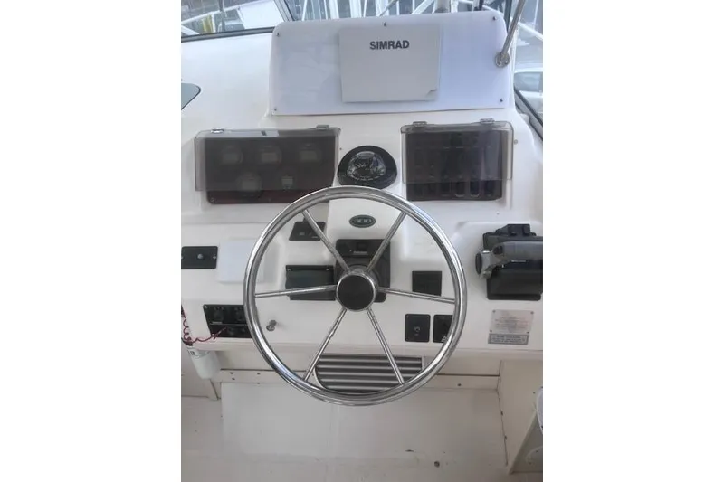 Slide: The Image of 1999 Grady-White Marlin 300 helm with steering wheel and Simrad electronics. - 12