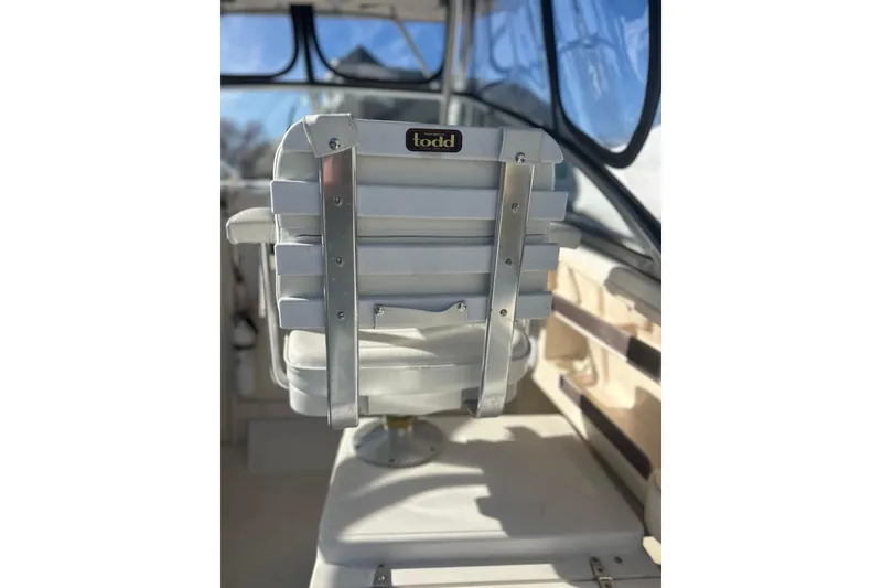 Slide: The Image of Captain's chair on 1999 Grady-White Marlin 300 boat, featuring sturdy metal frame. - 13