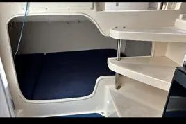 Slide: The Image of 1999 Grady-White Marlin 300 cabin interior with blue bedding and white steps. - 18