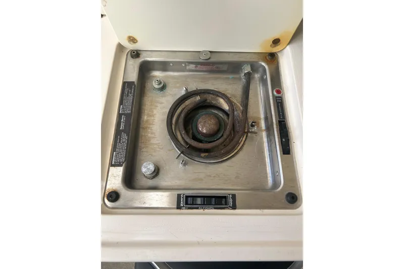 Slide: The Image of 1999 Grady-White Marlin 300 boat stove with single burner and control panel. - 19
