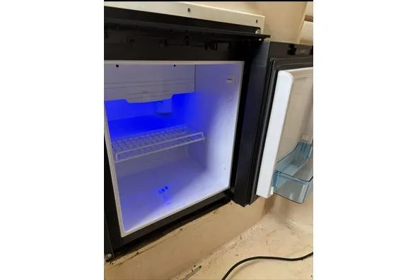 Slide: The Image of Open refrigerator with blue interior light on a 1999 Grady-White Marlin 300 boat. - 21