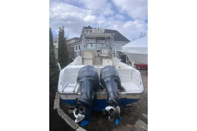 Slide: The Image of 1999 Grady-White Marlin 300 boat with dual outboard motors, docked outdoors. - 24