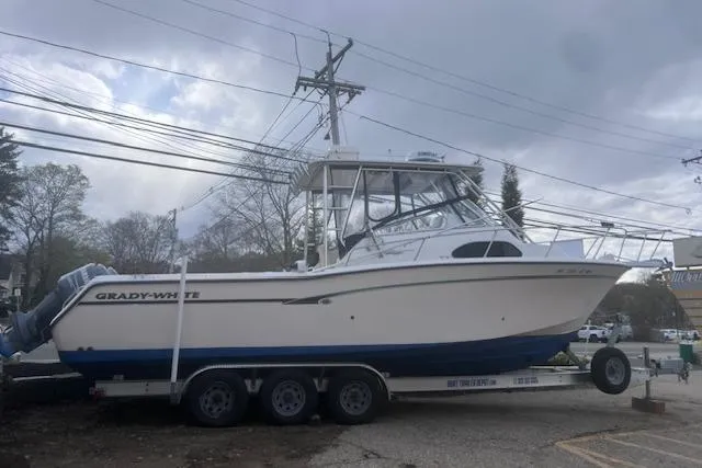 Slide: The Image of 1999 Grady-White Marlin 300 boat on trailer, overcast sky background. - 6