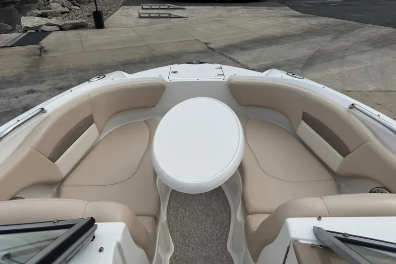 Slide: The Image of 2012 Chaparral 224 Sunesta boat interior with beige seating and a round table. - 18