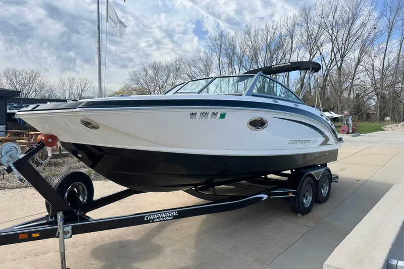 Slide: The Image of 2012 Chaparral 224 Sunesta boat on trailer, parked outdoors under cloudy sky. - 2