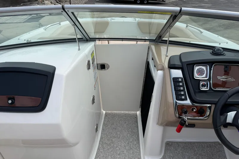 Slide: The Image of 2012 Chaparral 224 Sunesta boat interior with dashboard and open cabin door. - 20