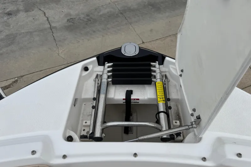 Slide: The Image of 2012 Chaparral 224 Sunesta boat ladder compartment open, showing retractable ladder. - 21