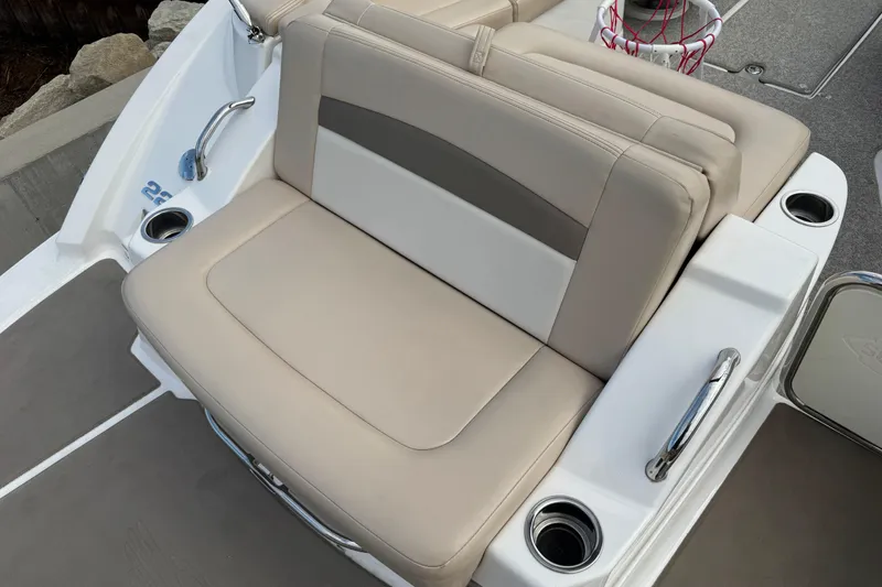 Slide: The Image of 2012 Chaparral 224 Sunesta boat seating area with beige upholstery and cup holders. - 22