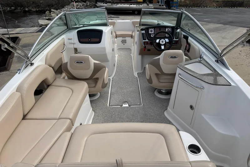 Slide: The Image of 2012 Chaparral 224 Sunesta boat interior with beige seating and modern dashboard. - 24
