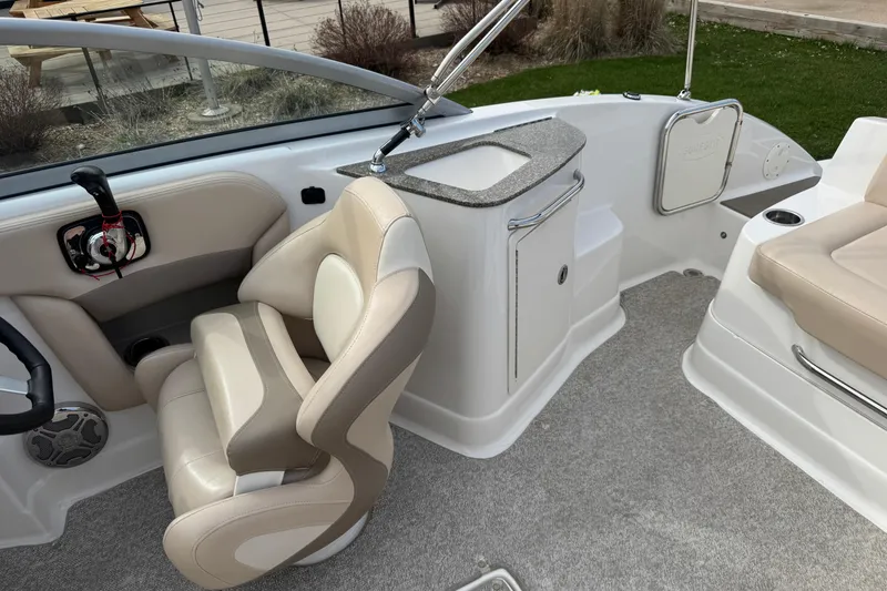 Slide: The Image of Interior of a 2012 Chaparral 224 Sunesta boat with beige seating and helm controls. - 26