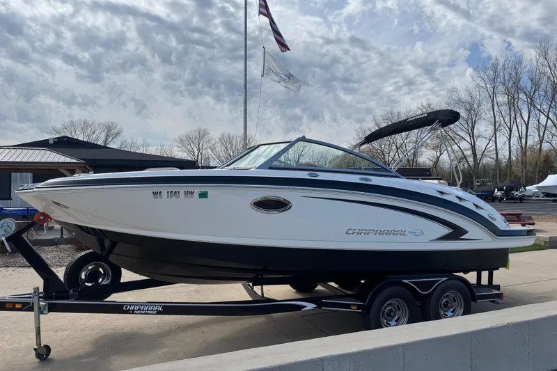 Slide: The Image of 2012 Chaparral 224 Sunesta boat on trailer, parked outdoors under cloudy sky. - 3