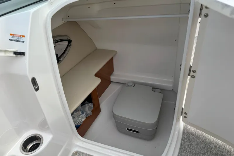 Slide: The Image of 2012 Chaparral 224 Sunesta boat interior storage compartment with portable toilet. - 30