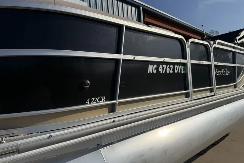 Slide: The Image of 2013 South Bay 422 CR pontoon boat with open storage compartments and cushioned seating. - 11
