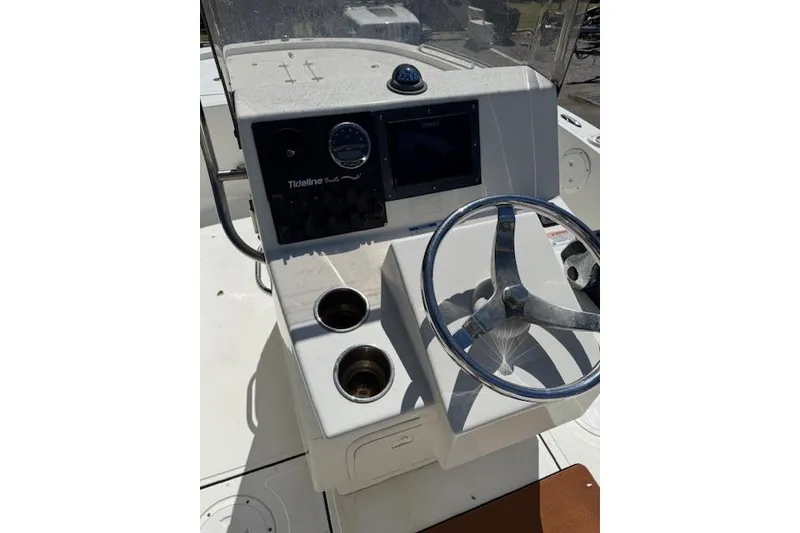Slide: The Image of Steering console of a 2013 Tideline 190 boat with cup holders and navigation controls. - 13