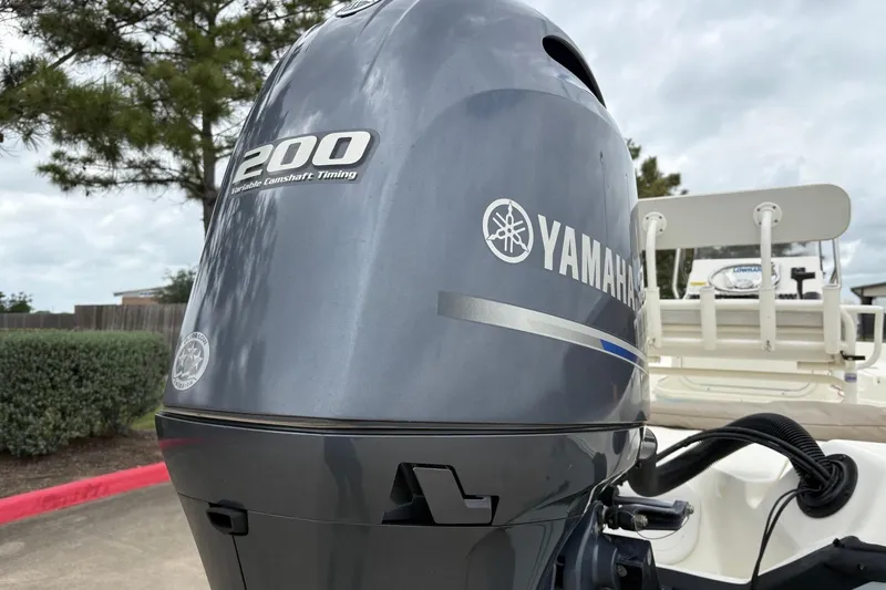 Slide: The Image of Yamaha 200 outboard motor on a 2015 Skeeter SX2250 boat, parked outdoors. - 6