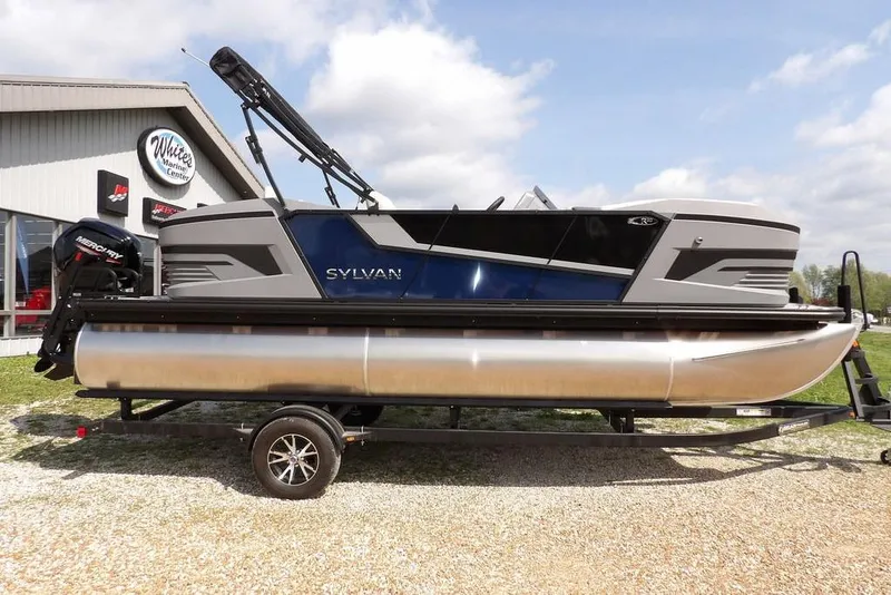 The Image of 2026 Sylvan R-20 PARTY FISH pontoon boat on trailer, displayed outdoors. - 1