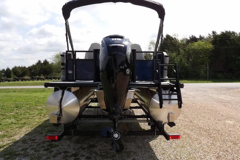 Slide: The Image of 2026 Sylvan R-20 PARTY FISH pontoon boat, rear view, parked on gravel. - 10