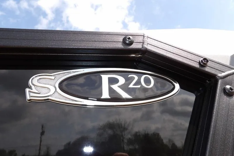 Slide: The Image of 2026 Sylvan R-20 PARTY FISH emblem on a sleek black surface under a blue sky. - 38