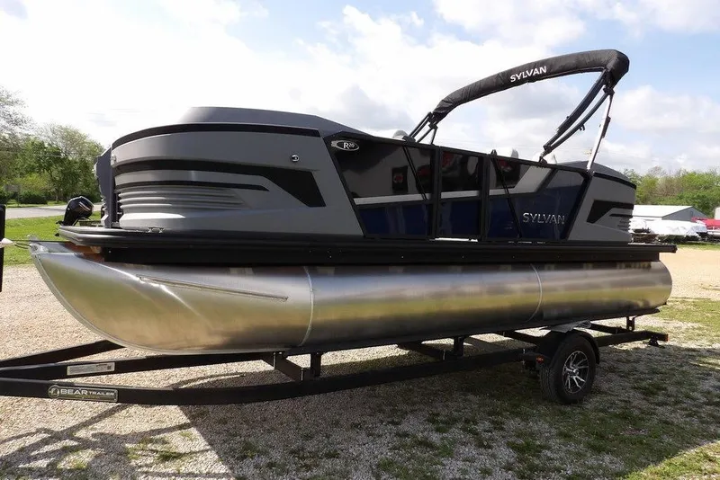 Slide: The Image of 2026 Sylvan R-20 PARTY FISH pontoon boat on trailer, parked outdoors. - 4