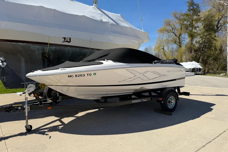 The Image of 2013 Regal 1900 Bowrider boat on trailer, covered, parked outdoors. - 0