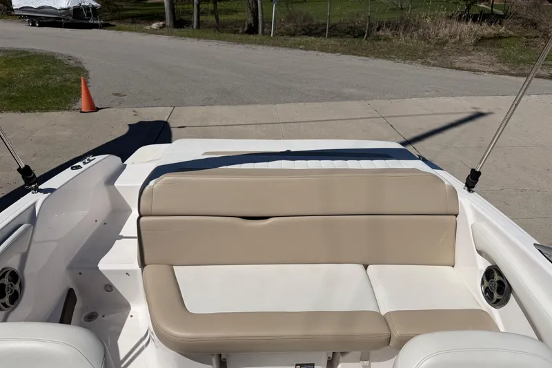 Slide: The Image of 2013 Regal 1900 Bowrider boat interior with beige seating and outdoor setting. - 20