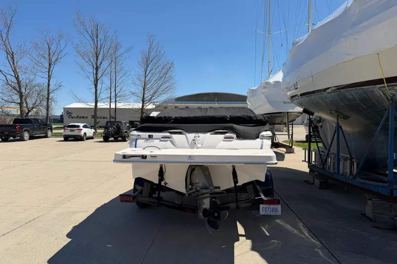 Slide: The Image of 2013 Regal 1900 Bowrider boat parked at a marina under clear blue skies. - 3