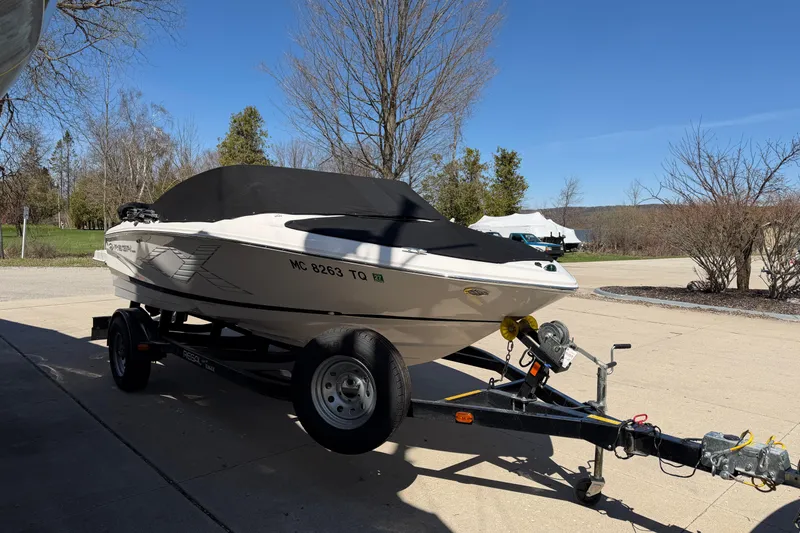 Slide: The Image of 2013 Regal 1900 Bowrider boat on trailer, parked outdoors on a sunny day. - 5