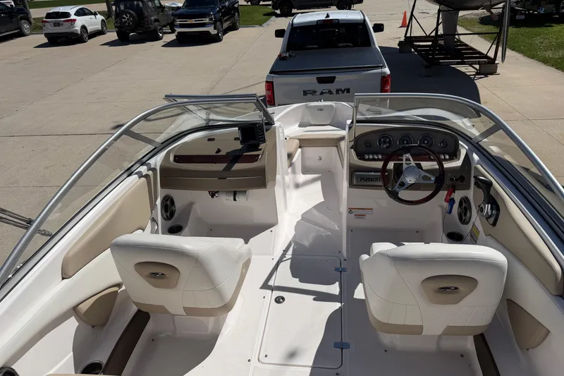 Slide: The Image of 2013 Regal 1900 Bowrider interior with steering wheel and seating, parked near vehicles. - 6