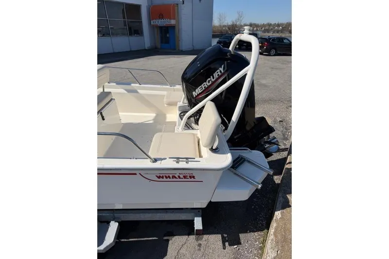 Slide: The Image of 2022 Boston Whaler 170 Montauk boat with Mercury engine, parked outdoors. - 4