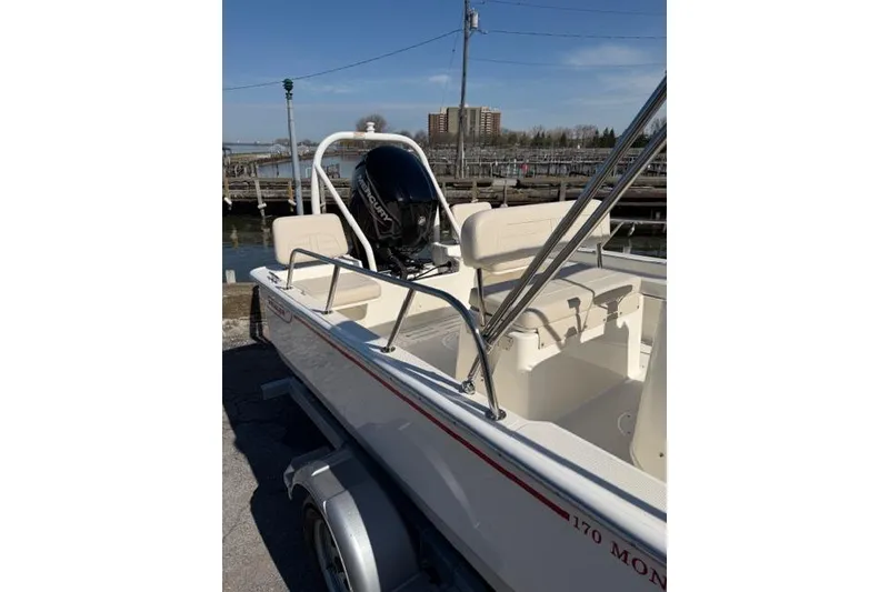 Slide: The Image of 2022 Boston Whaler 170 Montauk boat docked, showcasing sleek design and seating area. - 6