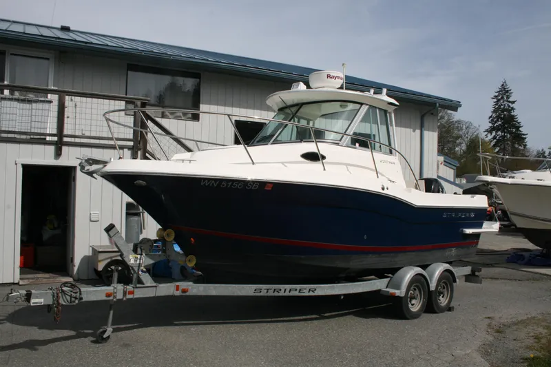 The Image of 2014 Seaswirl Striper 220 WA boat on trailer outside a building. - 0